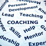 Collage of coaching-related words such as "Coaching," "Skills," "Mentor," "Personal Development," and "Leadership" printed on white cards, symbolizing the key elements of modern leadership.