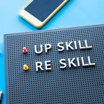 Upskilling vs reskilling concept on a pegboard with office supplies.