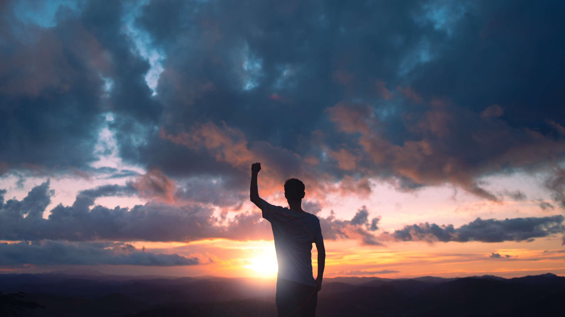 Motivated person silhouette raising fist at sunset, symbolizing self-discipline, personal growth, success, and motivation for professional development.