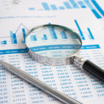 Magnifying glass focusing on financial data charts and Excel tables with a pen, representing data analysis, business reporting, and advanced Excel skills