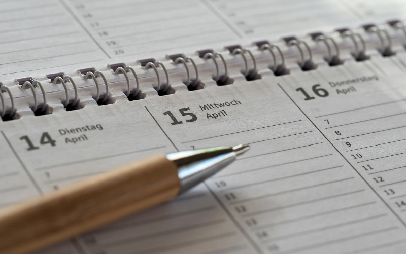 Close-up of a planner with scheduled dates and a pen, representing time management, planning, and professional organization.